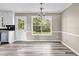Bright dining area with new laminate flooring, modern chandelier, and view to outside at 60 Whispering Pine Ct, Covington, GA 30016