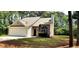 Charming single-Gathering home with stone accents, a two-car garage and a well-maintained lawn at 60 Whispering Pine Ct, Covington, GA 30016