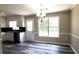 White kitchen cabinets and backsplash meet gray wood floors and natural light at 60 Whispering Pine Ct, Covington, GA 30016