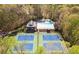 Aerial view of the neighborhood pool and tennis courts surrounded by a lush, wooded landscape at 815 Lake Forest Pass, Roswell, GA 30076