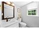 Bright bathroom with a decorative mirror over the sink and natural light from the window at 815 Lake Forest Pass, Roswell, GA 30076