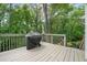 View of a covered grill sitting on the home's deck overlooking lush greenery at 815 Lake Forest Pass, Roswell, GA 30076