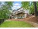 Rear view of the house, showcasing its multiple decks, manicured lawn and fenced yard at 815 Lake Forest Pass, Roswell, GA 30076