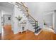 Bright foyer with hardwood floors, a staircase with decorative iron railings, and neutral paint at 815 Lake Forest Pass, Roswell, GA 30076