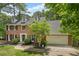 Lovely brick home showcasing well-maintained landscaping, a two-car garage, and classic architectural details at 815 Lake Forest Pass, Roswell, GA 30076