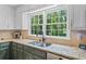 Kitchen featuring granite countertops, stainless steel appliances, and a large window overlooking the trees at 815 Lake Forest Pass, Roswell, GA 30076