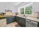Bright kitchen with stainless steel appliances, granite countertops, and a large sink with a window view at 815 Lake Forest Pass, Roswell, GA 30076