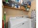 A laundry room with a washer and dryer and shelving unit for storage at 815 Lake Forest Pass, Roswell, GA 30076