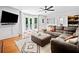 Living room with hardwood floors, wet bar, sectional sofa, ceiling fan, and access to the deck at 815 Lake Forest Pass, Roswell, GA 30076