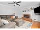 Cozy living room featuring a brick fireplace, hardwood floors, and ceiling fan at 815 Lake Forest Pass, Roswell, GA 30076