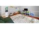 A playroom with wood floors, a white rug, and decorated with toys, books, and wall art at 815 Lake Forest Pass, Roswell, GA 30076