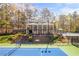 View of the tennis courts and pool with pavilion featuring stadium-style seating and landscaping at 815 Lake Forest Pass, Roswell, GA 30076
