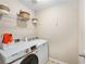 Bright laundry room features modern Samsung washer and dryer, plus convenient overhead storage shelves at 103 Harvest Rdg, Acworth, GA 30102