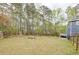 Large fenced backyard featuring mature trees, playground, and a seating area at 130 Brandon Mill Cir, Fayetteville, GA 30214