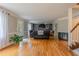 Open living room with hardwood floors, a fireplace, custom built-ins, and a view of the staircase at 130 Brandon Mill Cir, Fayetteville, GA 30214