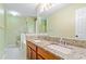 A bright bathroom with granite countertops, a double vanity, and white tile flooring at 2114 Lindley Nw Ln, Kennesaw, GA 30144