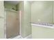 Standing shower with glass doors with granite topped nook for toiletries at 2114 Lindley Nw Ln, Kennesaw, GA 30144