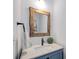 Bathroom with a rustic-framed mirror above a vanity with light countertops and blue cabinets at 300 Massengale Rd, Brooks, GA 30205