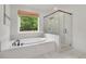 Bright bathroom with tub and separate glass shower with natural light at 300 Massengale Rd, Brooks, GA 30205
