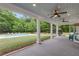 Large covered patio with ceiling fans overlooks pool and large backyard with trees at 300 Massengale Rd, Brooks, GA 30205