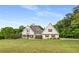 Charming two-story home with a manicured front lawn and mature trees in the background at 300 Massengale Rd, Brooks, GA 30205