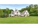 Beautiful white home with manicured lawn and mature trees in a serene setting at 300 Massengale Rd, Brooks, GA 30205