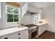 This kitchen has custom white cabinets, light countertops, and a stainless steel stove and hood at 300 Massengale Rd, Brooks, GA 30205