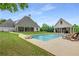 Backyard view of a refreshing pool with lounge chairs and a covered pool house at 300 Massengale Rd, Brooks, GA 30205