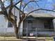 View of the front exterior, which includes a chain link fence, tree, and small front porch at 701 Garibaldi St, Atlanta, GA 30310