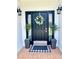 Elegant black front door with a decorative wreath, flanked by potted plants and stylish lanterns at 805 Doe Hill Ln, Roswell, GA 30075
