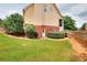 Lawn with trimmed bushes lead to the back of home with access door at 2726 Riderwood Ne Ln, Marietta, GA 30062