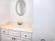 Bathroom vanity with white cabinets, oval mirror and cultured marble countertop at 2726 Riderwood Ne Ln, Marietta, GA 30062
