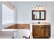 Bright bathroom with tub, travertine tile surround, and a granite topped wood vanity at 2726 Riderwood Ne Ln, Marietta, GA 30062