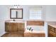 Bathroom featuring a drop-in tub, tiled surround, and vanity with a granite countertop at 2726 Riderwood Ne Ln, Marietta, GA 30062