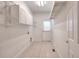 Functional laundry room with white cabinets, tile flooring, and a rear entry door at 2726 Riderwood Ne Ln, Marietta, GA 30062