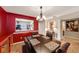 Open dining area boasts stylish lighting, red accent wall, and convenient pass-through to the adjacent kitchen at 4118 Stillwater Dr, Duluth, GA 30096