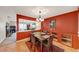 Formal dining room with rich red walls, seating for four, and a view to the living room at 4118 Stillwater Dr, Duluth, GA 30096