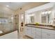 Bright bathroom featuring granite countertops, double sinks, vanity lighting, and glass enclosed shower at 404 Carryback Dr, Marietta, GA 30068