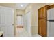 Hallway with neutral walls and tile floors, leading to the white door and wooden cabinets at 404 Carryback Dr, Marietta, GA 30068