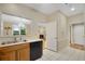 Kitchen featuring wood cabinetry, black dishwasher, and view to fireplace at 404 Carryback Dr, Marietta, GA 30068