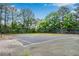 Fenced community tennis court that needs maintenance surrounded by mature trees at 404 Carryback Dr, Marietta, GA 30068
