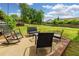 Spacious backyard with a patio featuring outdoor seating, set against a backdrop of lush greenery and blue skies at 4147 Suzanne Ln, Duluth, GA 30096