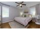 Cozy bedroom with ceiling fan, neutral walls, and a decorative rug accentuating the hardwood floors at 4147 Suzanne Ln, Duluth, GA 30096