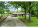 Charming single-story home with a well-maintained lawn, mature trees, and a welcoming red front door at 4147 Suzanne Ln, Duluth, GA 30096