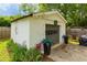 Detached garage with gray door, complemented by potted plants and surrounded by green grass at 4147 Suzanne Ln, Duluth, GA 30096