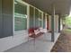 A charming front porch with a red metal bench and gray painted trim at 4147 Suzanne Ln, Duluth, GA 30096