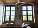 Living room with exposed brick walls, oversized windows, and a modern ceiling fan at 170 Boulevard Se # H301, Atlanta, GA 30312