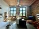 Inviting living room boasts exposed brick, high ceilings, and abundant natural light from large windows at 170 Boulevard Se # H301, Atlanta, GA 30312