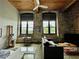Open-concept living area boasts exposed brick, large windows, and modern furnishings for comfortable living at 170 Boulevard Se # H301, Atlanta, GA 30312