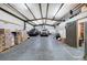Spacious garage with concrete floor, metal ceiling, and two trucks parked inside at 200 Rogers Rd, Kingston, GA 30145